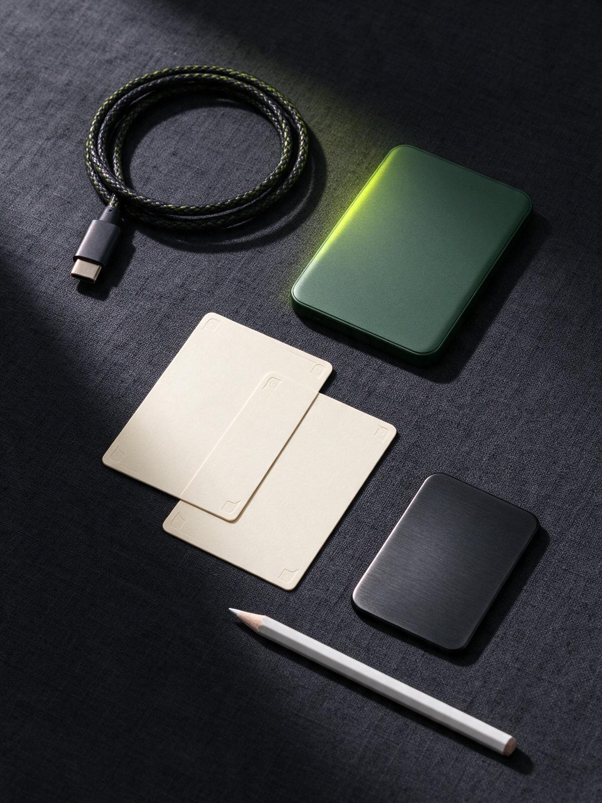 Hardware wallet, braided cable, blank recovery cards and pencil on dark linen
